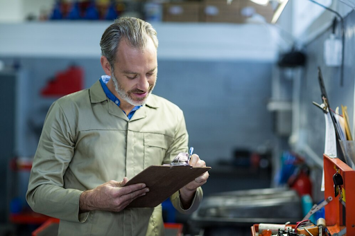 Mechanic writing on a clipboard
